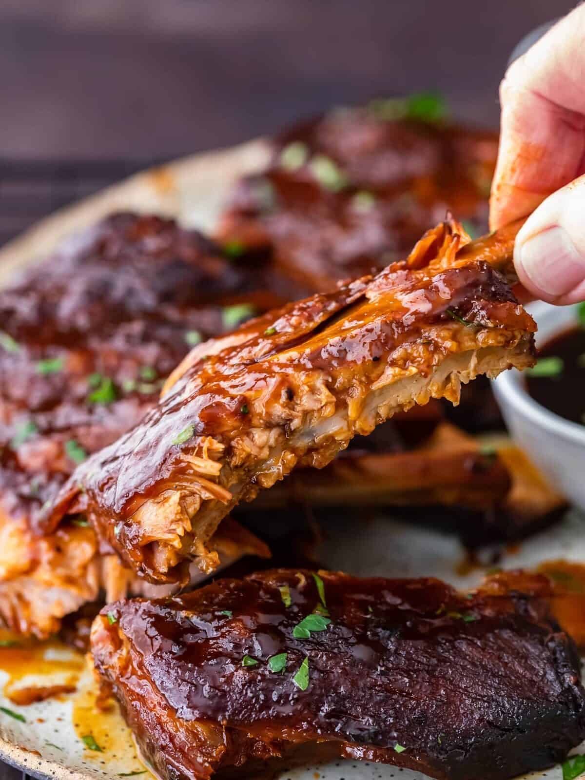 Crock Pot Ribs are an easy way to make the most delicious ribs for any occasion. This slow cooker ribs recipe is so simple! You can cook these crock pot BBQ ribs stress-free, and they'll come out super tender and flavorful. slow cooker ribs on a plate
