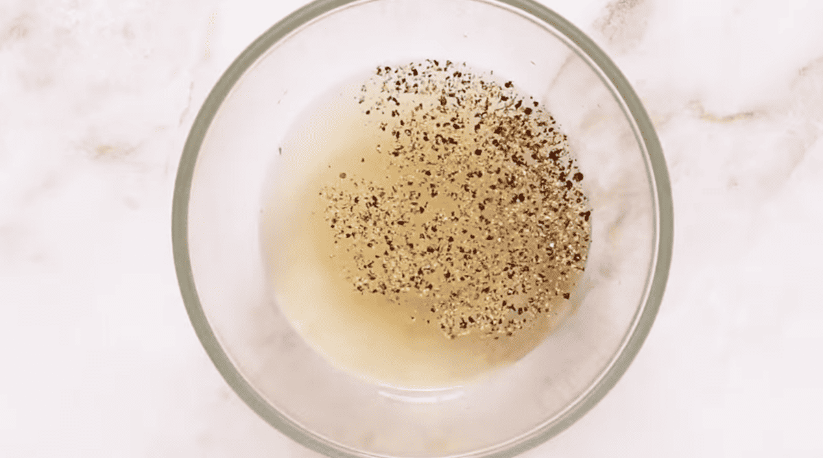 vinegar dressing with pepper in a glass bowl.