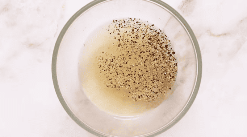 vinegar dressing with pepper in a glass bowl.
