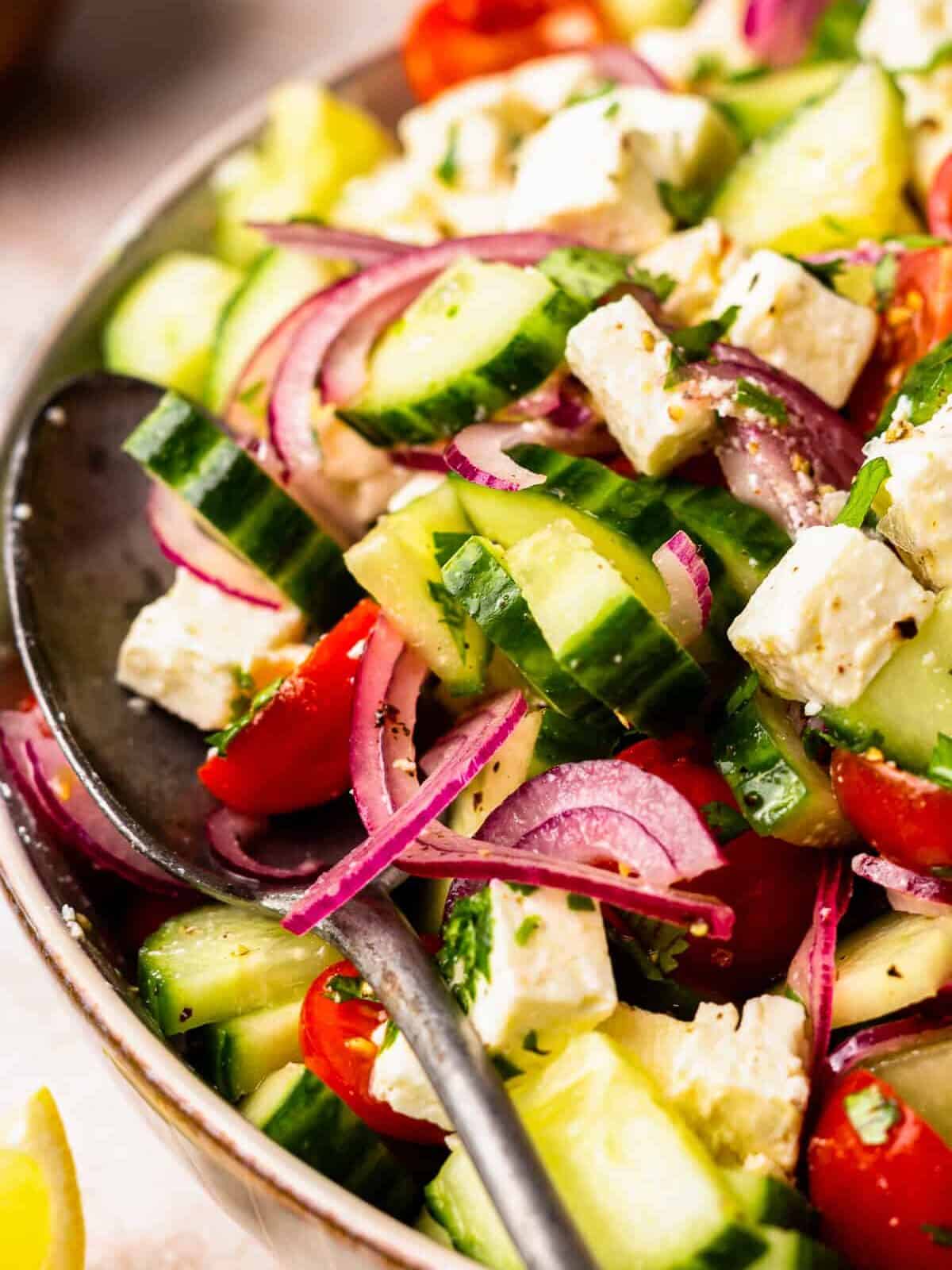 close up on a serving spoon sitting in a salad