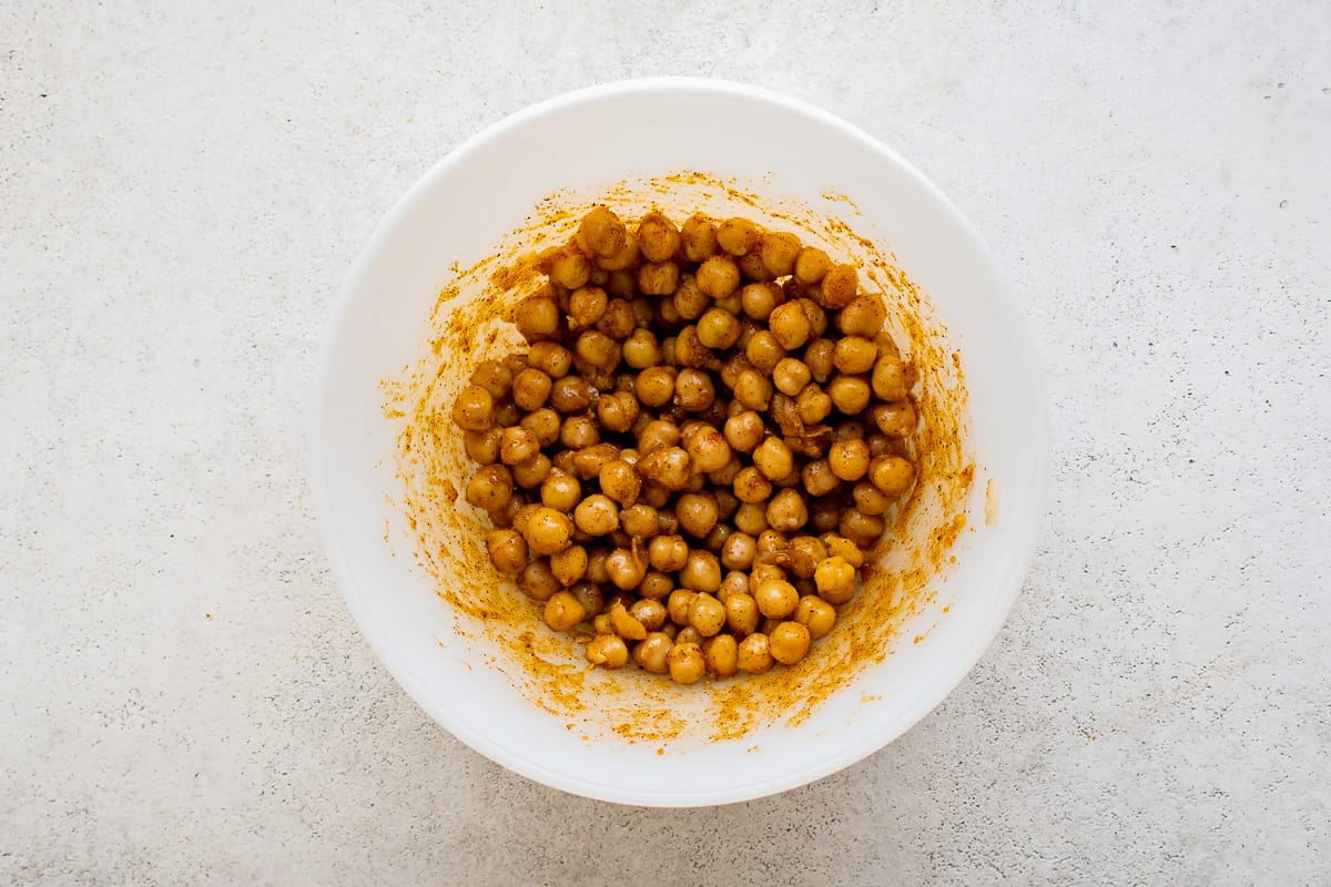 chickpeas in a bowl on a white surface.