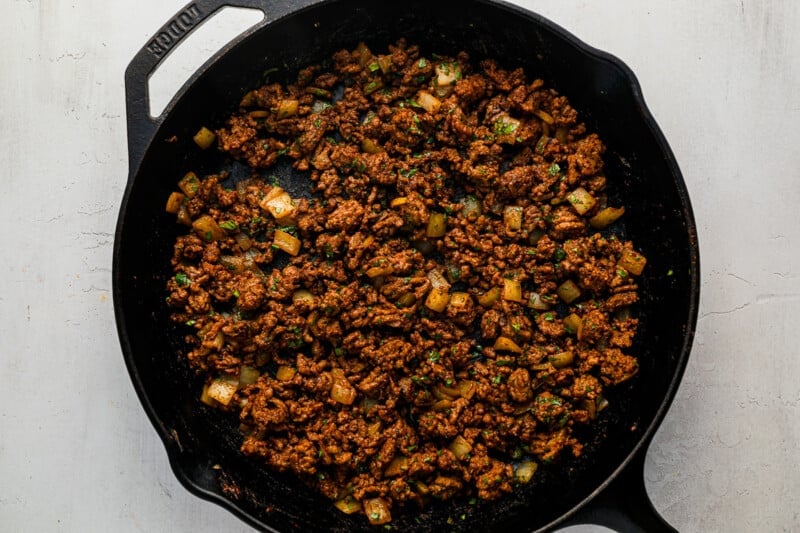 a cast iron skillet filled with meat and vegetables.