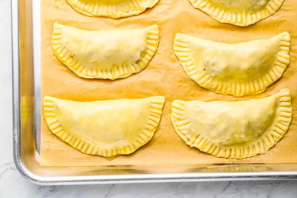 a baking sheet with a tray full of raviolis.