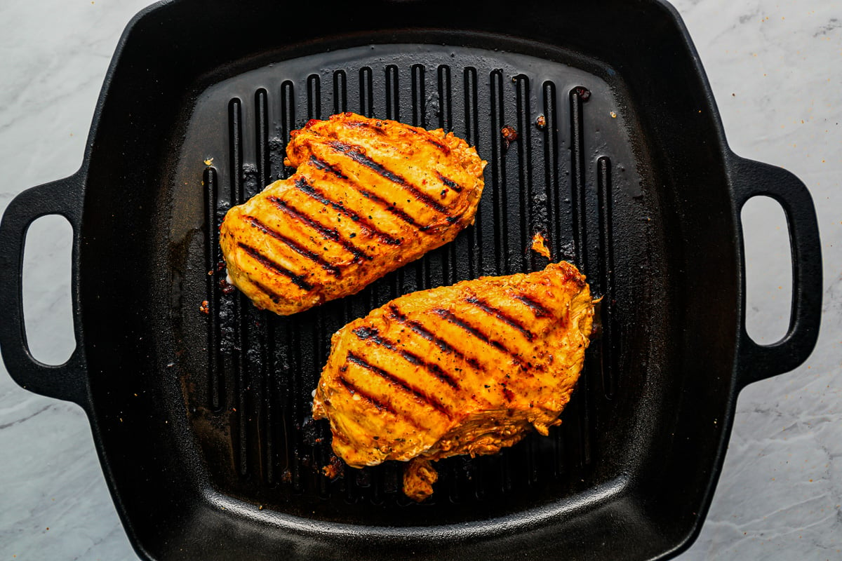 two grilled chicken breasts in a pan.