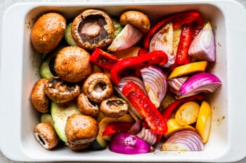 overhead view of mixed sliced vegetables on a small baking sheet.