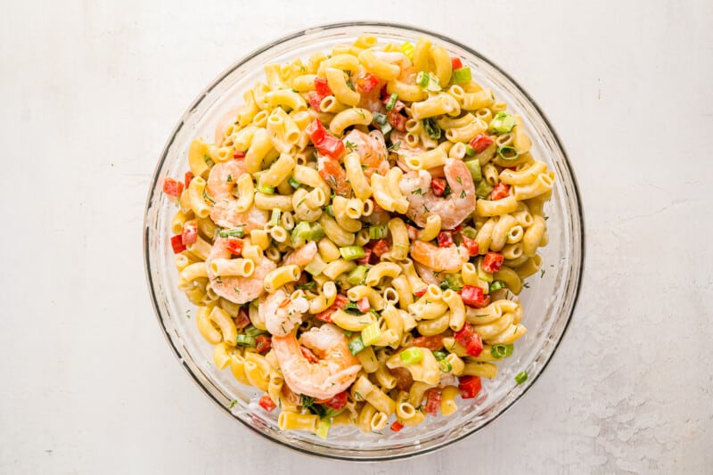 dressed shrimp pasta salad in a glass bowl.