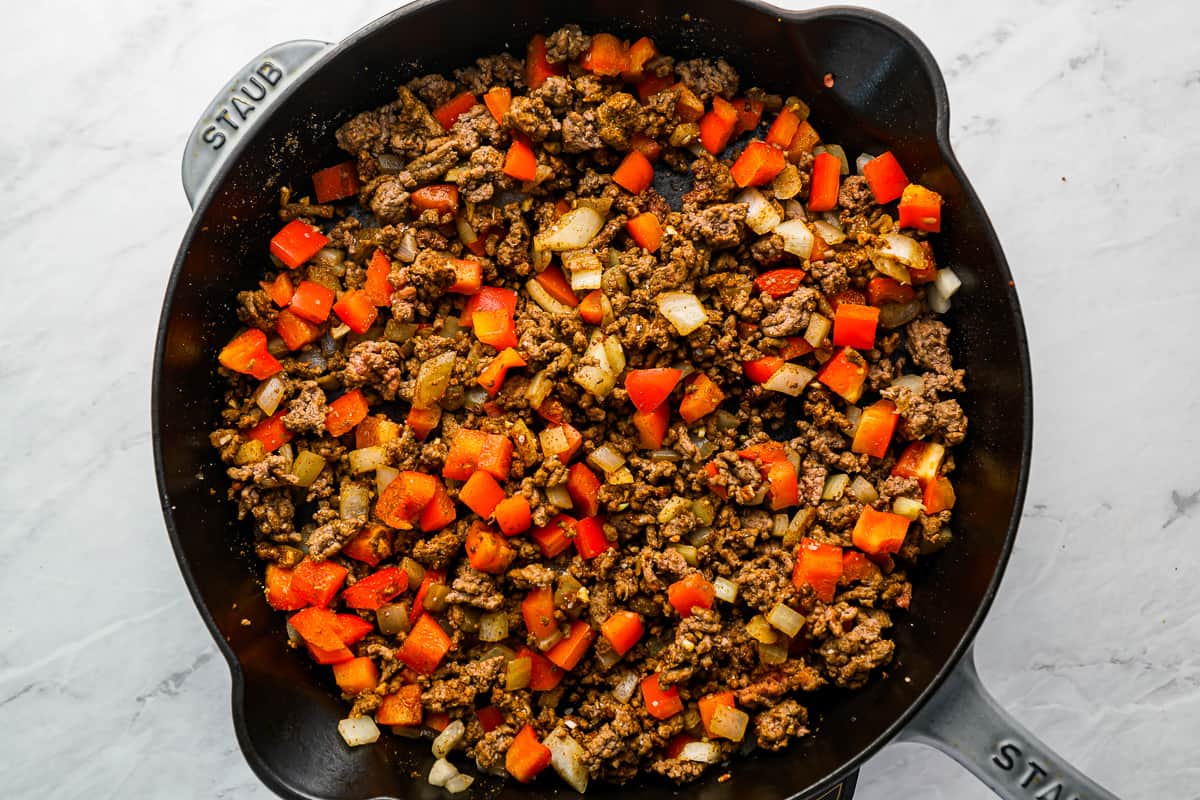 a skillet filled with ground beef and vegetables.