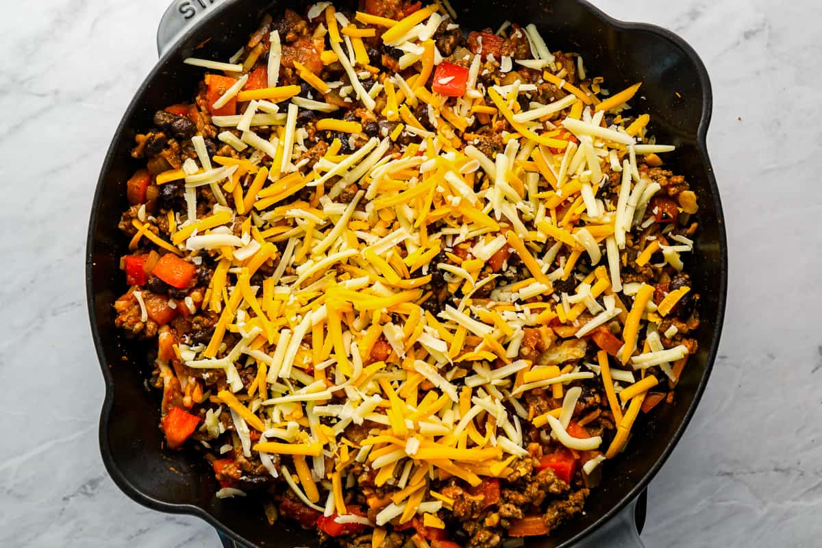 a skillet filled with cheesy mexican rice.