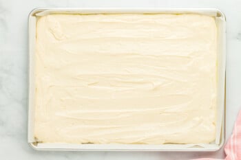 vanilla cake batter spread out in a sheet cake pan.