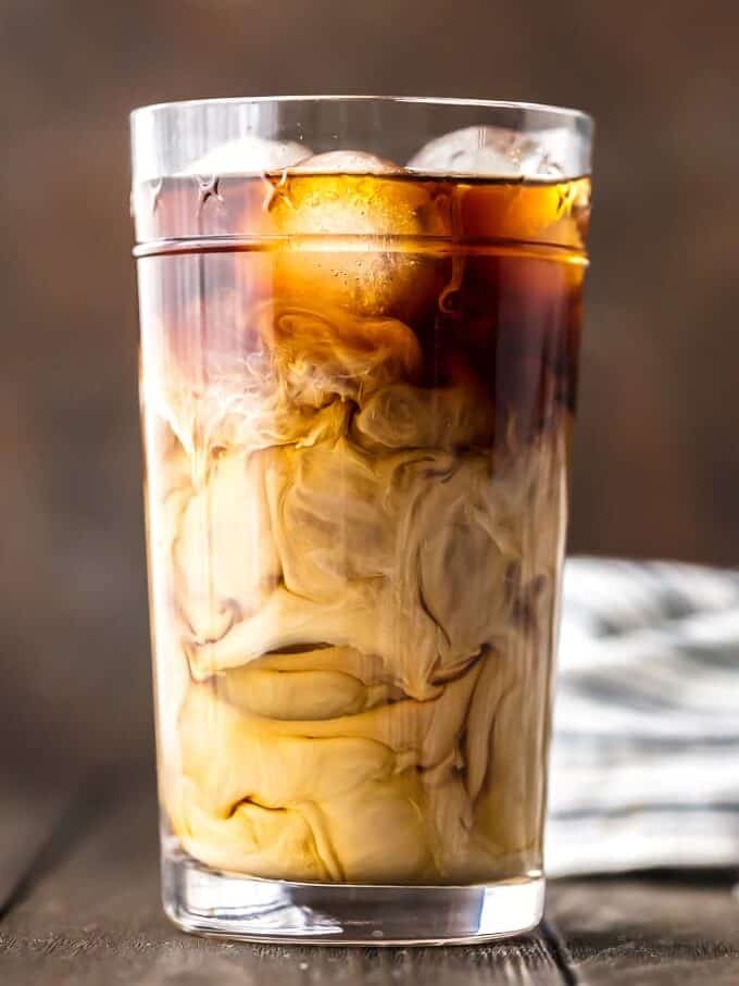 Iced Coffee is so easy to make, and even more delicious than what you can buy at Starbucks! If you've ever wondered how to make iced coffee at home, you've come to the right place. This Cold Brew Coffee recipe is EASY, delicious, perfectly sweet, and so addicting. Having a glass of this Homemade Iced Coffee Recipe is the best way to start your day. iced coffee with cream in a glass