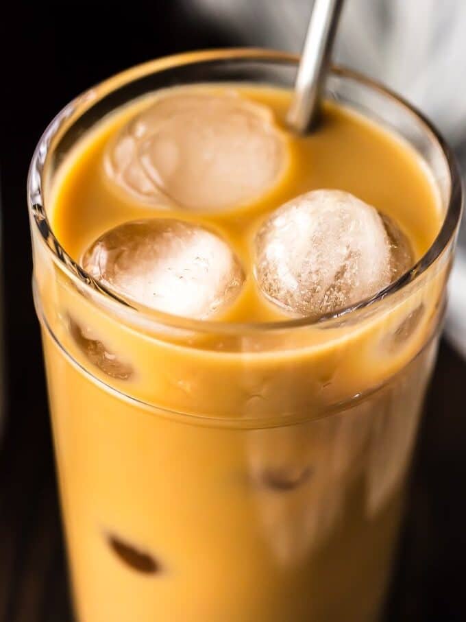 up close picture of iced coffee with cream in a glass