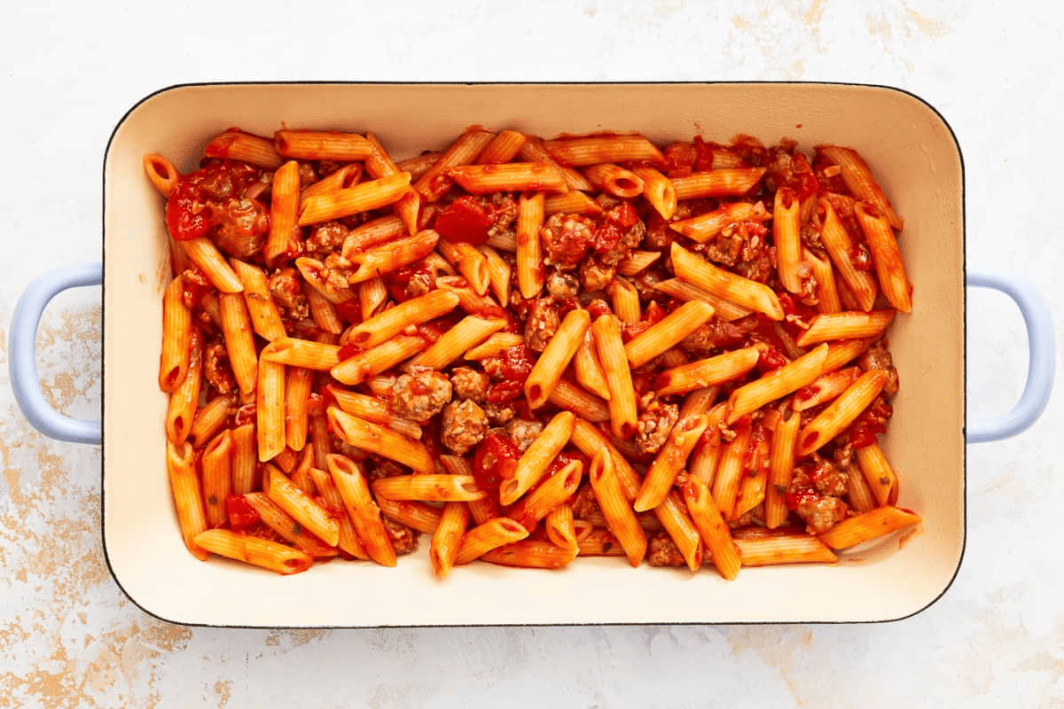 Half of the pasta sauce mixture in a baking dish.