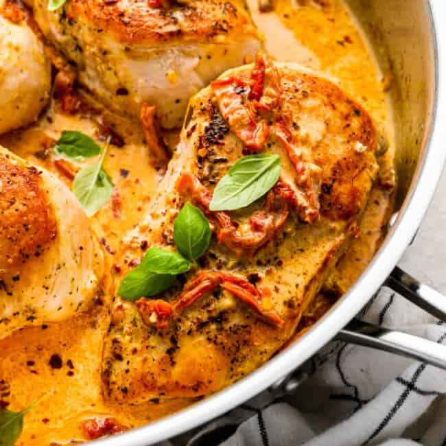 close-up three-quarters view of marry me chicken in a stainless pan.