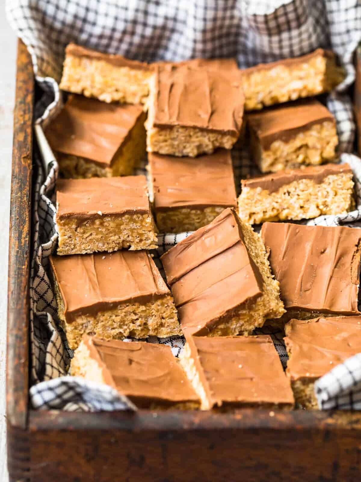 sliced scotcheroos in a box topped with chocolate