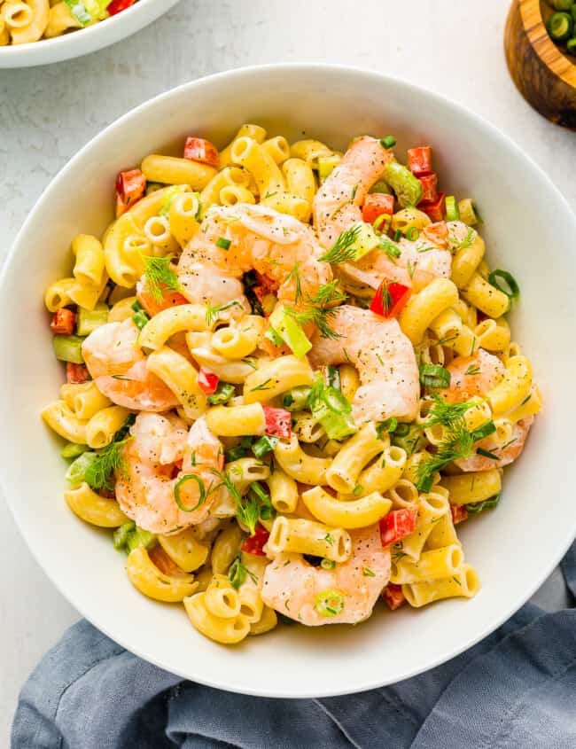 overhead view of shrimp pasta salad in a white bowl.