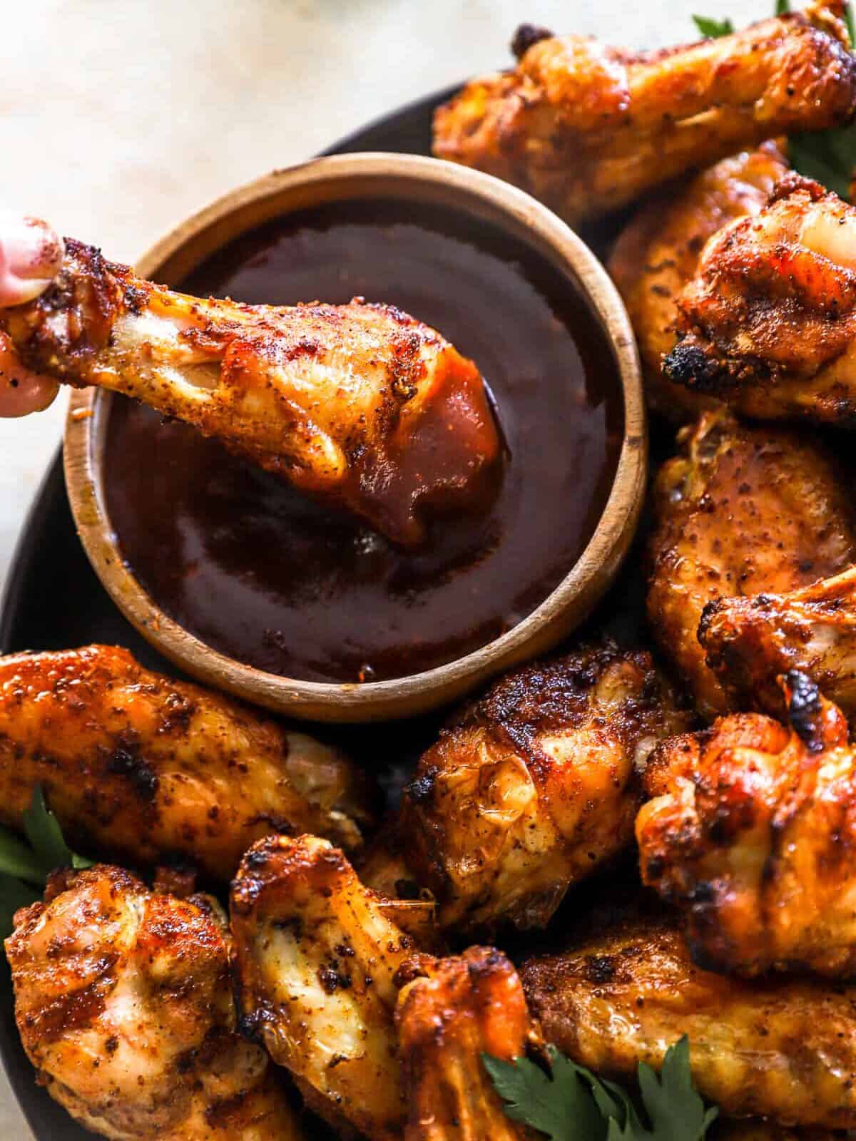 a smoked chicken wing dipped in barbecue sauce.
