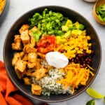 mexican chicken rice bowl with sour cream and guacamole.