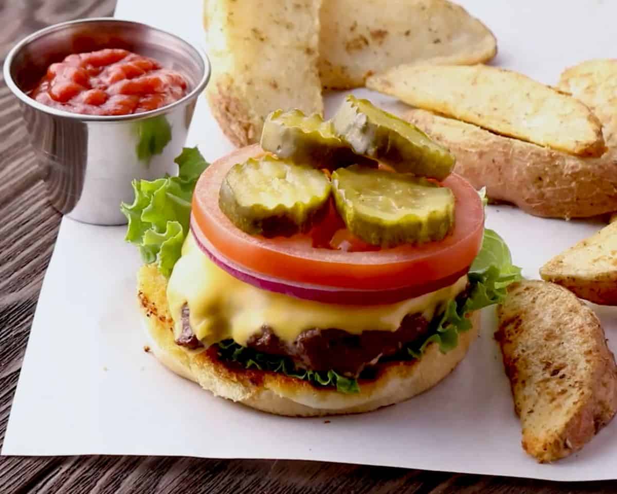 seared burger patty with a deeply browned crust, cooking in a skillet