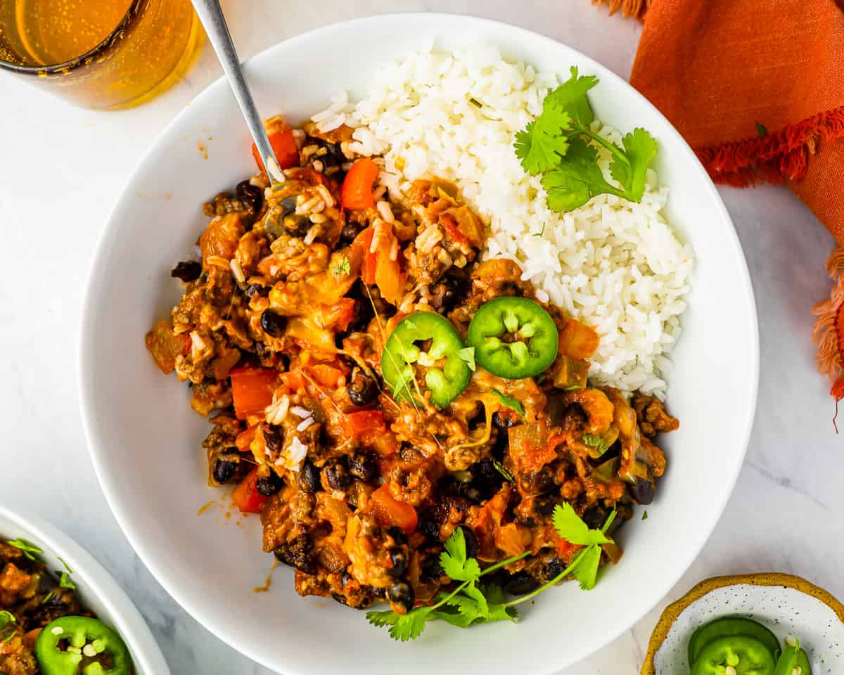 taco skillet in a bowl of rice with a spoon.