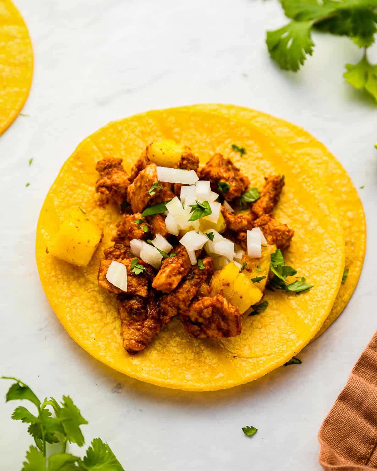 tortillas filled with al pastor taco meat.
