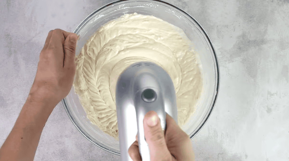 beaten cake batter in a glass bowl.