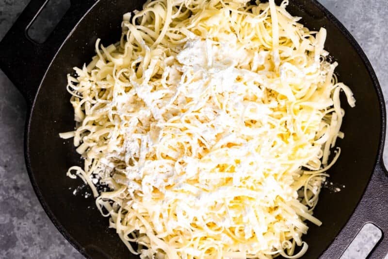 Freshly grated cheese and cornstarch in a cast iron pan.