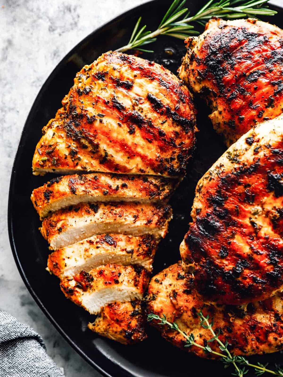 a plate of grilled marinated chicken breasts