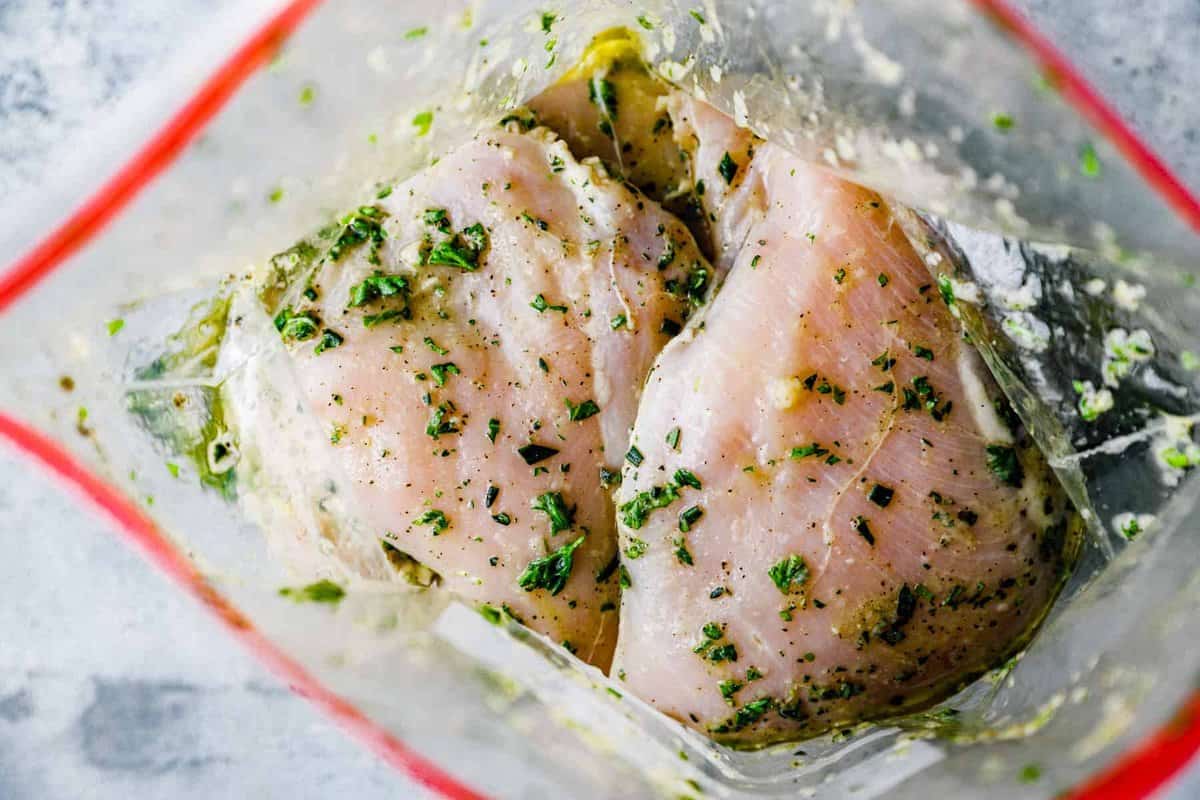 chicken breasts covered in a grilled chicken marinade, inside of a resealable bag