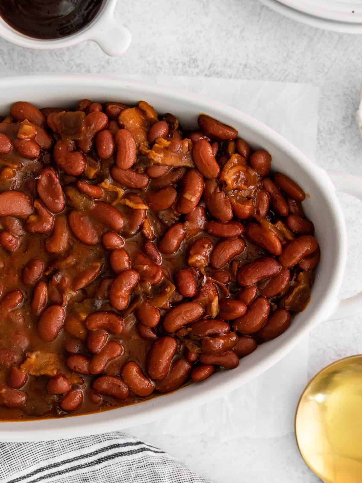 partial view of instant pot bbq baked beans in a white serving dish.