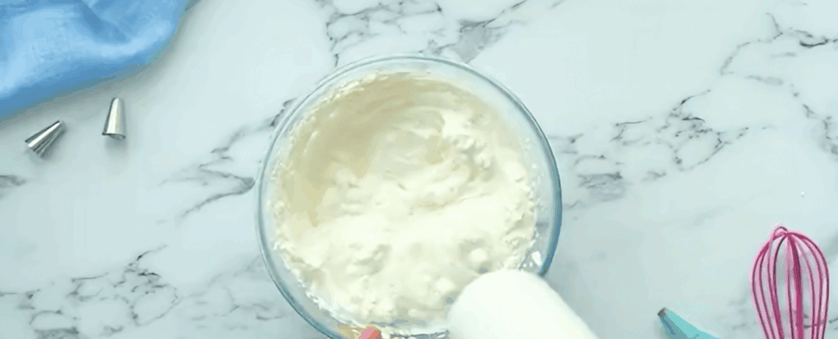 Whipping the cream so stiff peaks form.
