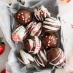 overhead view of strawberry truffles in a small parchment lined basket.