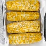 overhead image of 4 ears of corn on the cob on a serving platter