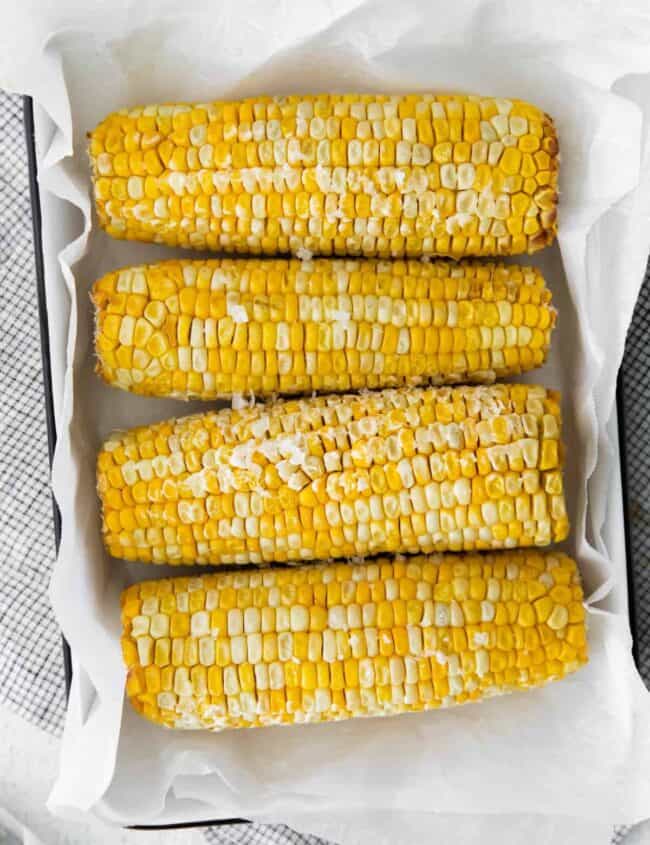 overhead image of 4 ears of corn on the cob on a serving platter