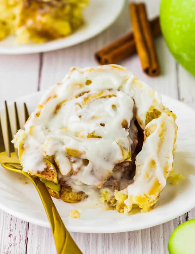 apple cinnamon rolls with icing on a plate.