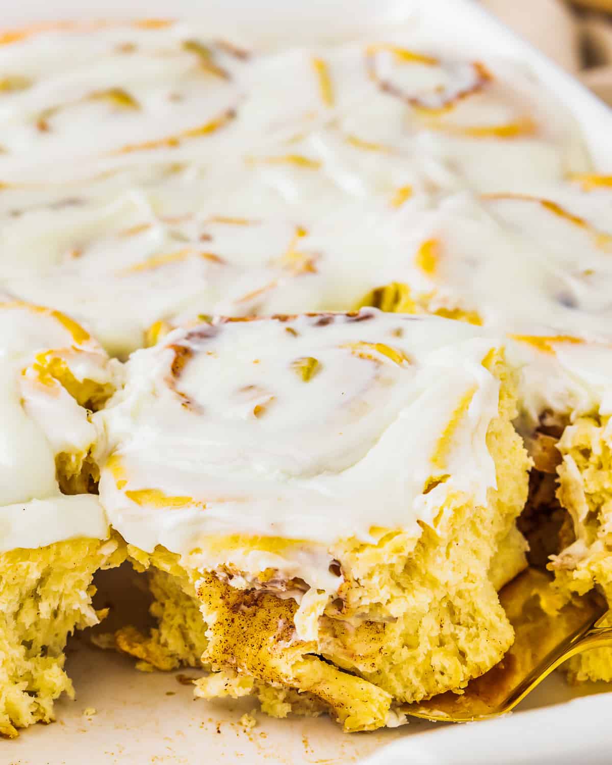 apple cinnamon rolls with icing on a white plate.