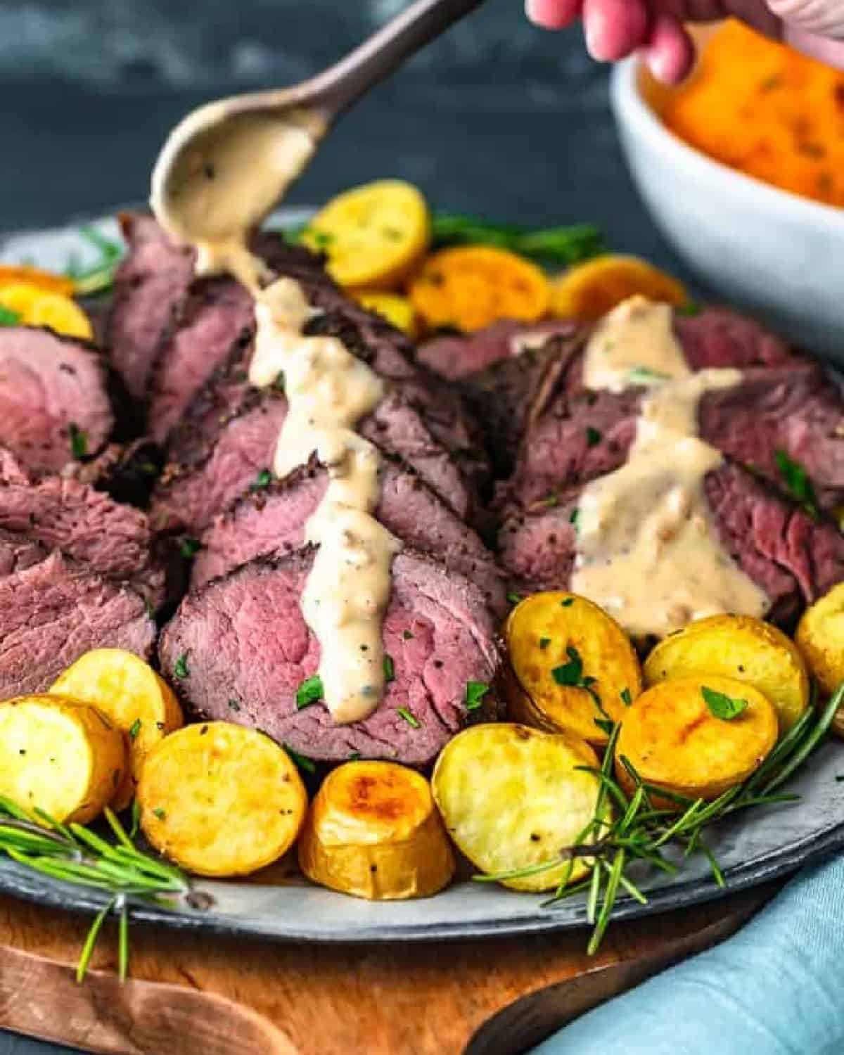 pouring mustard sauce over beef tenderloin