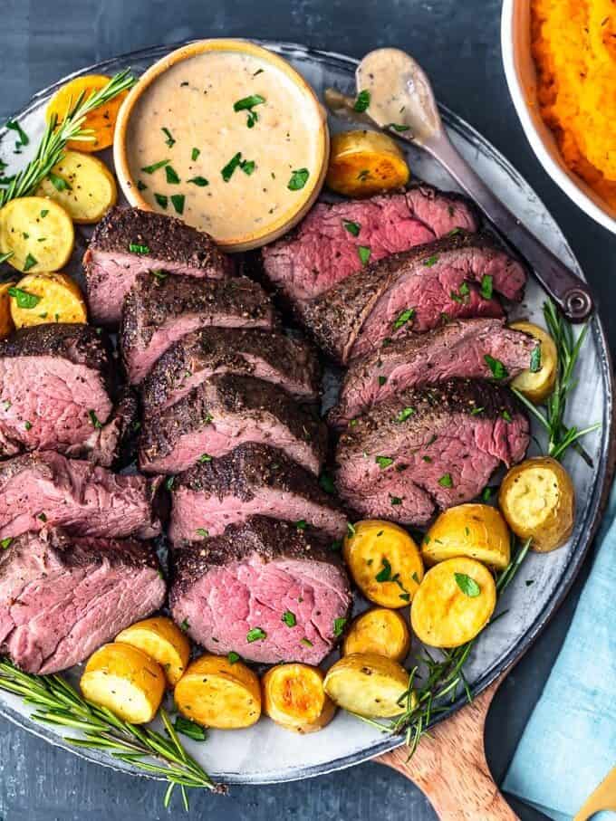 the best beef tenderloin recipe on a plate with brandy cream sauce and potatoes