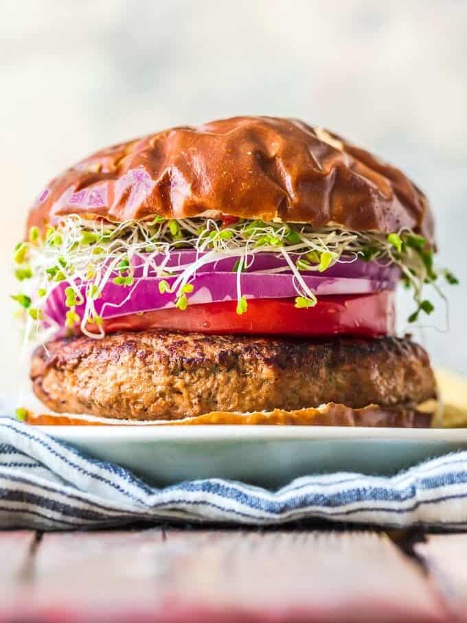 from view of a healthy turkey burger recipe topped with tomatoes, onions, and microwgreens