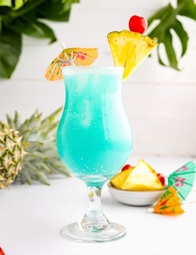 blue hawaiian cocktail with pineapples and umbrellas.