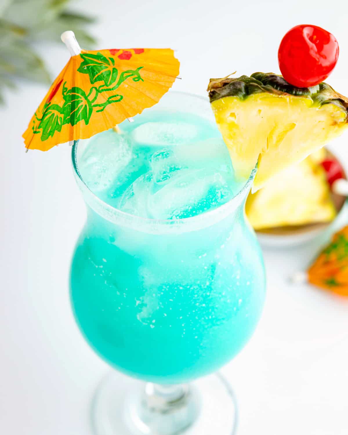 a blue Hawaiian drink with pineapples and an umbrella.
