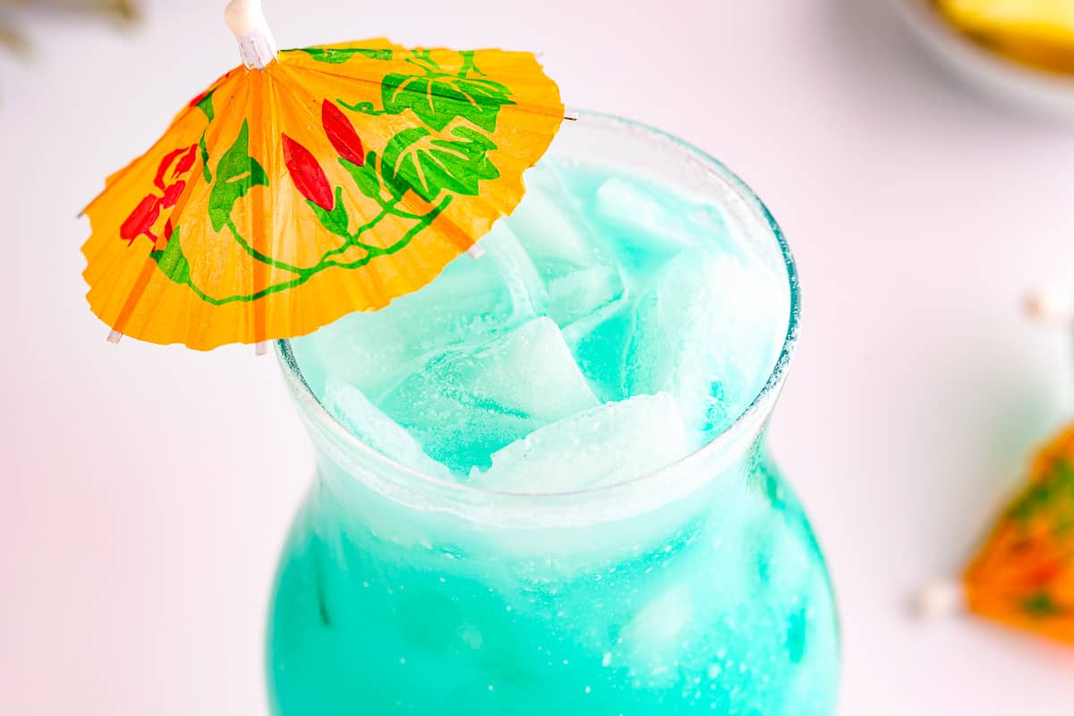 a blue drink with a yellow umbrella next to it.