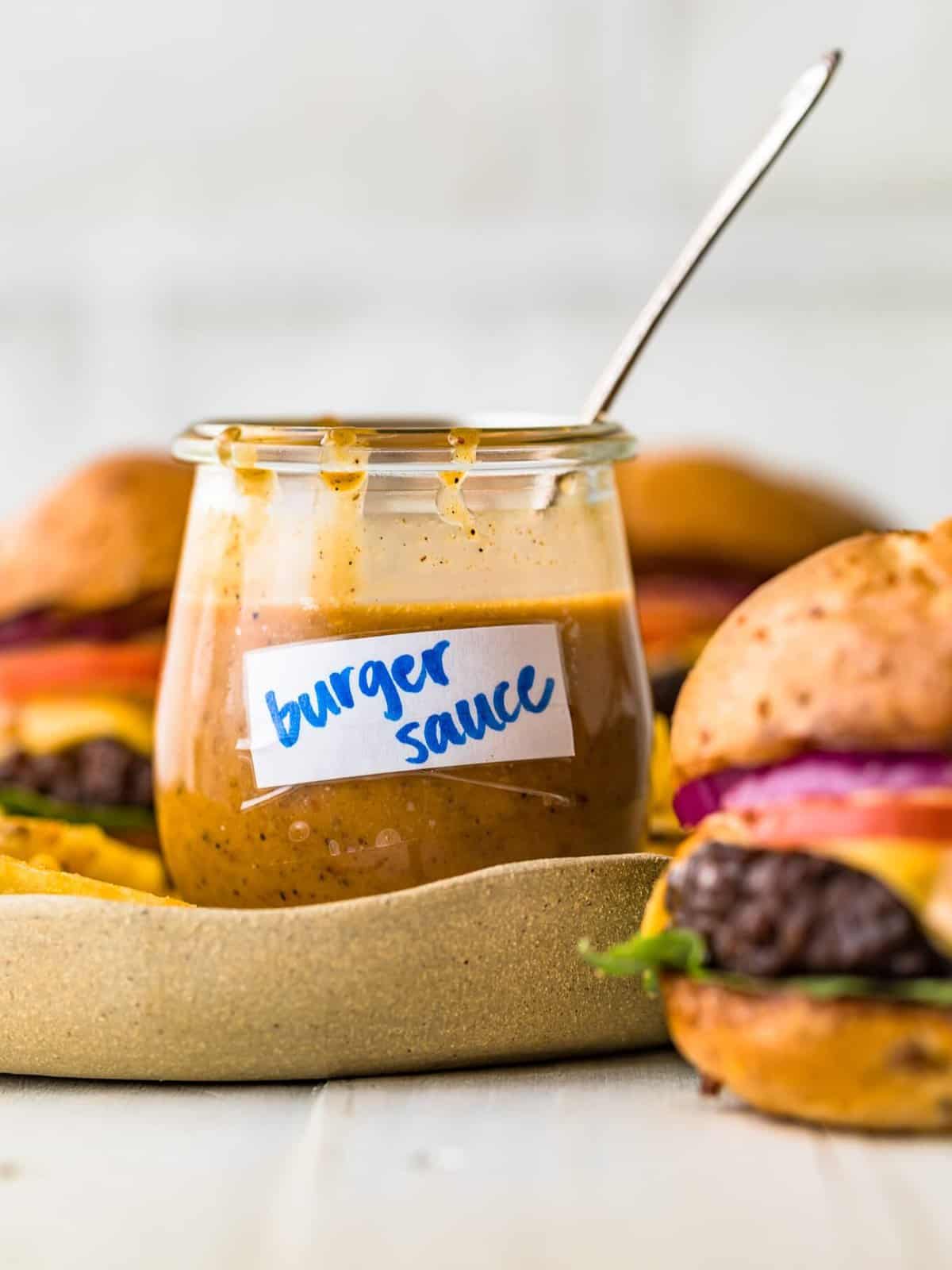 a small jar filled with homemade burger sauce, with a spoon sticking out of it