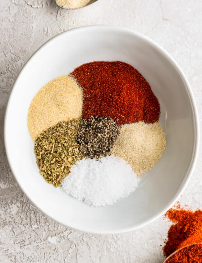 a white bowl filled with spices and seasonings.