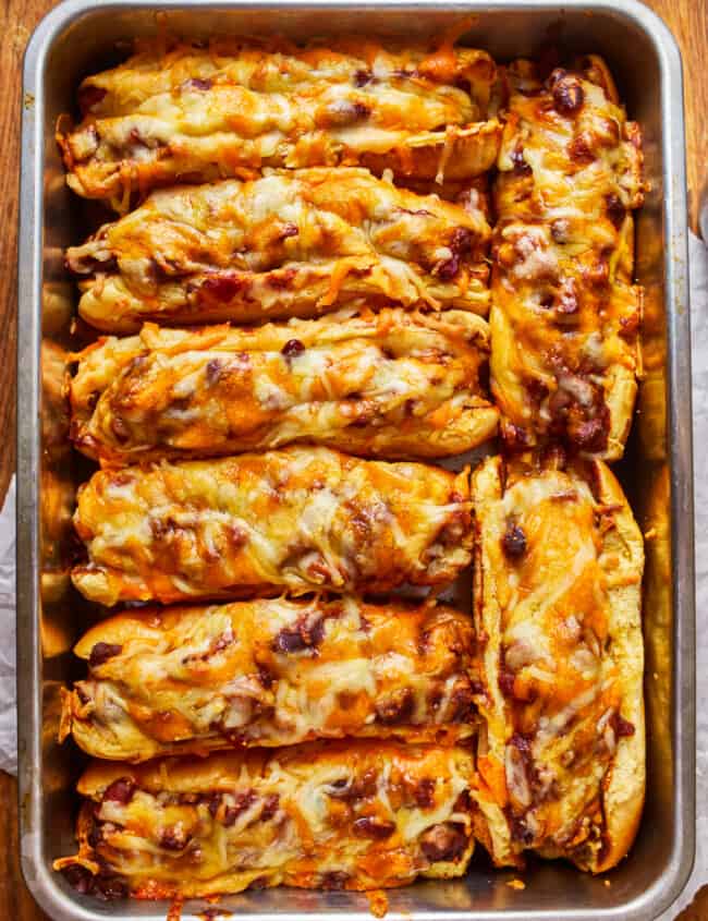 overhead view of 8 chili dogs in a baking pan.