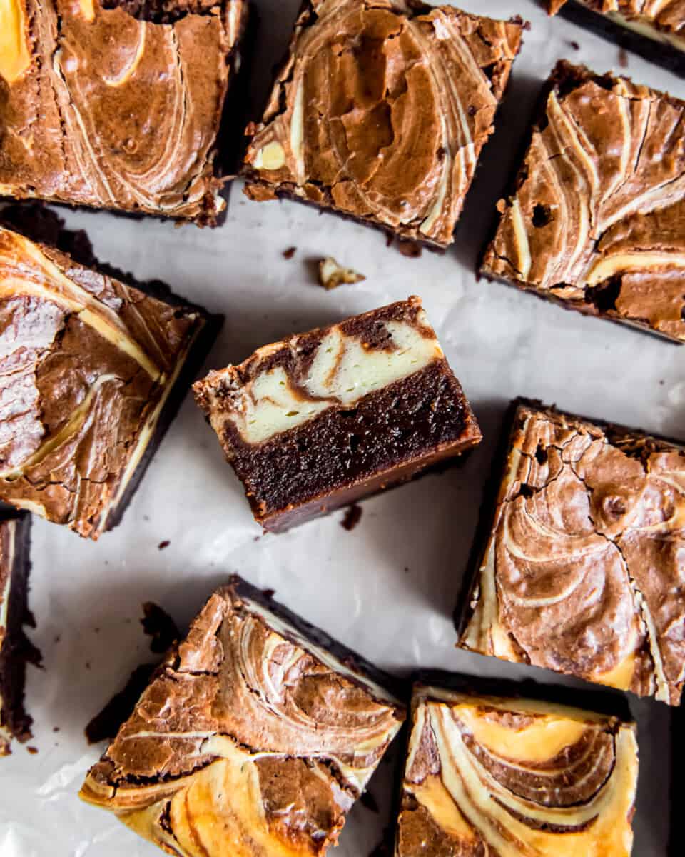 overhead view of cream cheese brownies, one is turned on its side to show the layers.