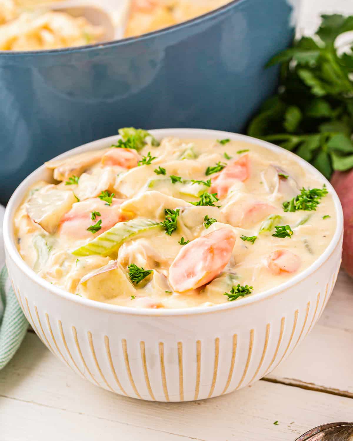 a bowl of chicken and potato stew on a white table.