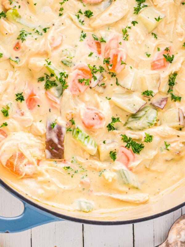 chicken chowder in a blue pot with carrots and bread.