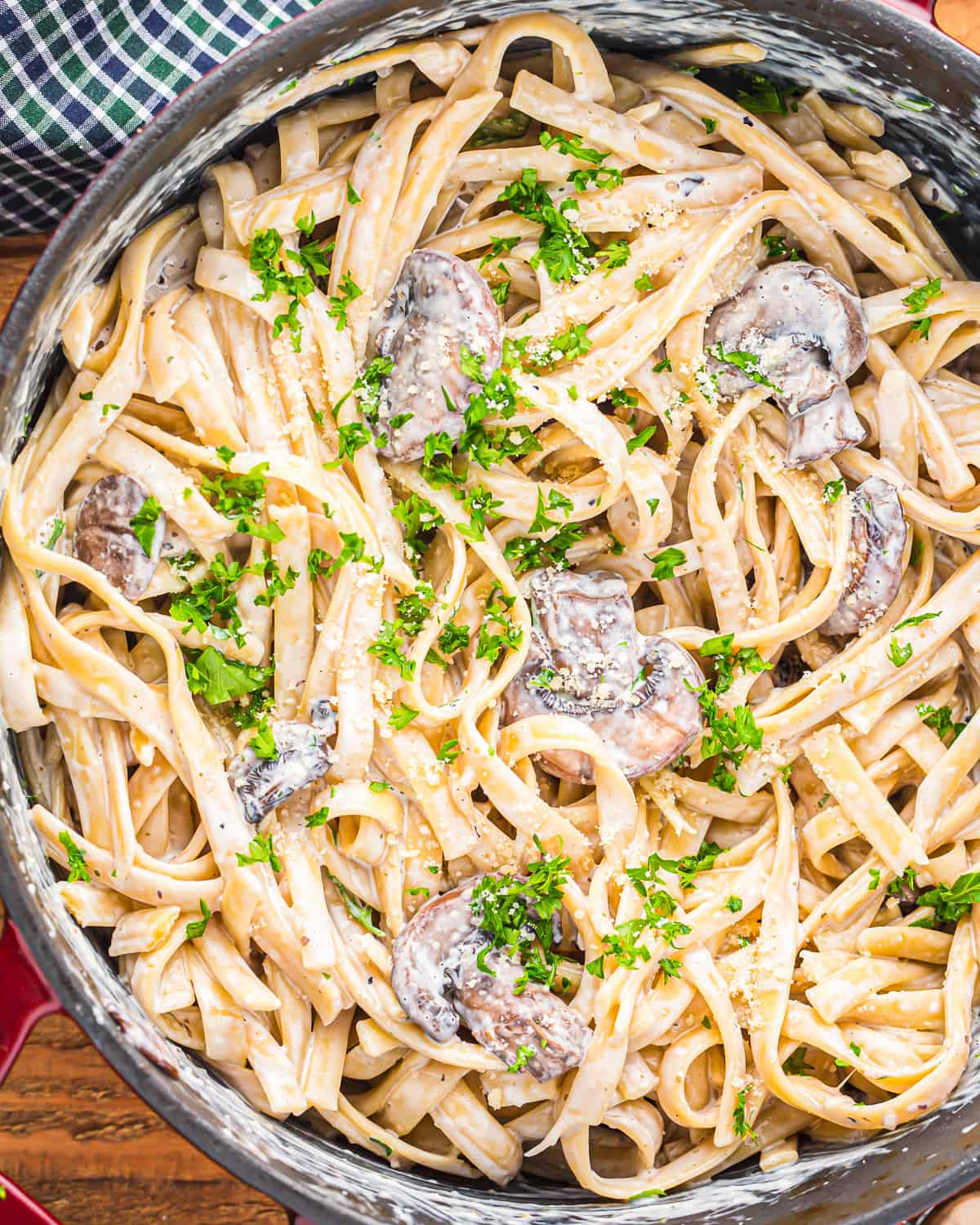 a pan of creamy pasta with mushrooms and parsley.