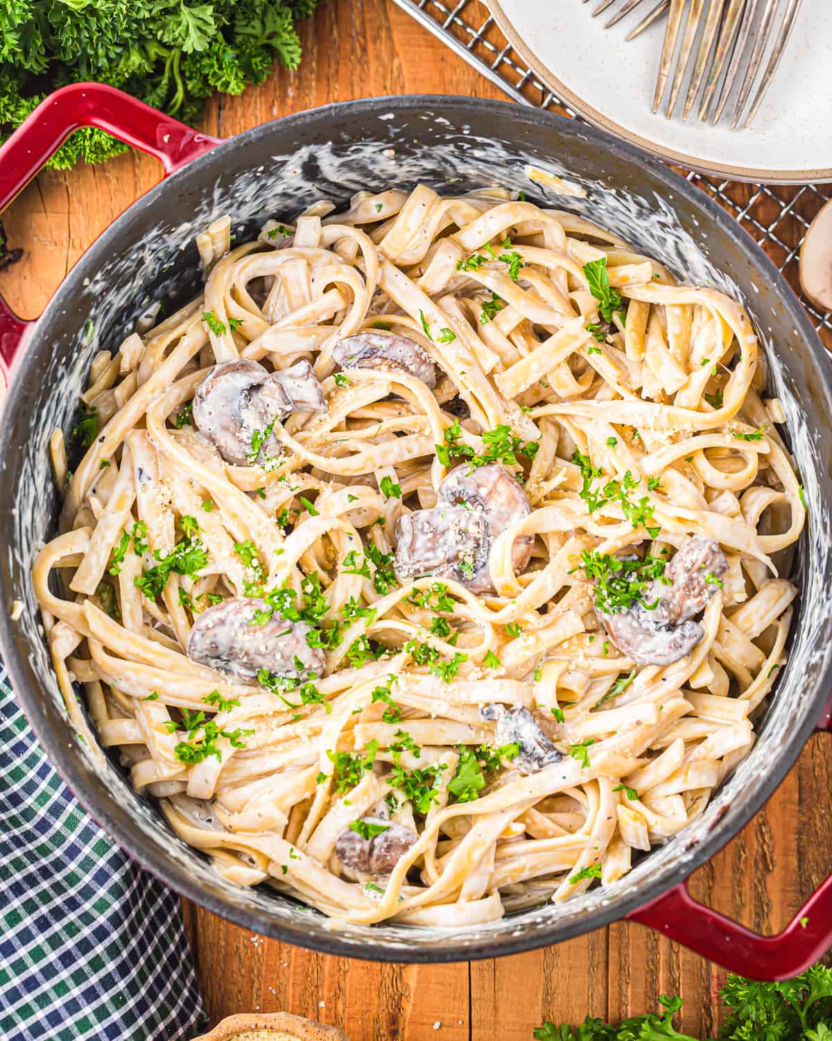 a pot full of creamy mushroom pasta, sprinkled with fresh parsley.