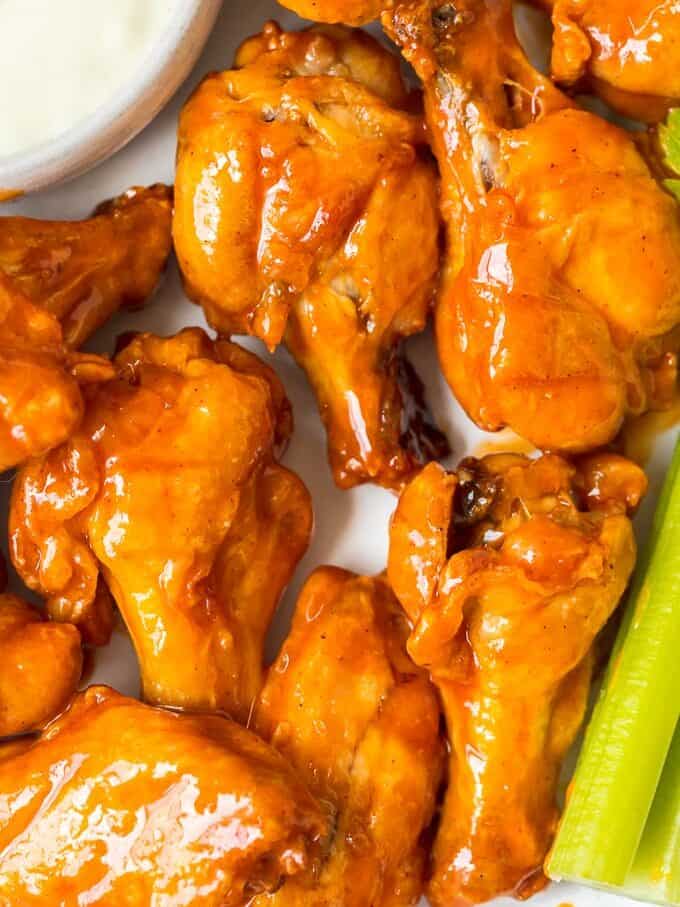 Baked Buffalo Wings are a tasty alternative to typical fried buffalo wings (and a bit healthier too!). These crispy baked chicken wings are covered in our homemade buffalo sauce for the perfect hot and spicy flavor. Baked Buffalo Chicken Wings are a real crowd pleaser and perfect for game day parties. You're going to love these crispy oven baked buffalo wings! close up on crispy buffalo wings